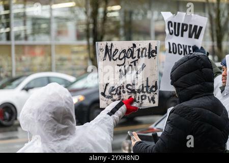 Vancouver, British Columbia, Kanada. Dezember 2024. Mitarbeiter der Canada Post streiken vor dem Büro des liberalen Abgeordneten Harjit Sajjan in Vancouver, British Columbia, um gegen den Abschnitt 107 des kanadischen Arbeitsgesetzes zu protestieren, der dem Minister für Arbeit die Macht gibt, sie wieder zu befehlen, mit jeder Lösung des Arbeitsstreits zu arbeiten. (Kreditbild: © Ryan Walter Wagner/ZUMA Press Wire) NUR REDAKTIONELLE VERWENDUNG! Nicht für kommerzielle ZWECKE! Quelle: ZUMA Press, Inc./Alamy Live News Stockfoto