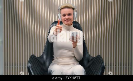 Glückliche Frau Weiße Mädchen Dame in Kopfhörern hören Musik futuristisch weiß Neon Hintergrund digitale Innovation Futurismus entspannender Klang weiblicher Tanz Stockfoto