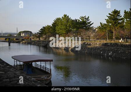 Landschaft mit malerischem Blick auf ein traditionelles hölzernes Fischerboot am Ufer des Uji-Flusses in Kyoto, Japan. Stockfoto