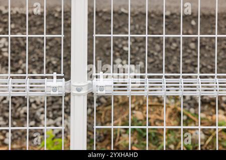 Weißer Stahlgitterzaun aus Draht, Industrieschutzzaun aus Gitterdraht, pvc-Metallzaunplatte. Stockfoto