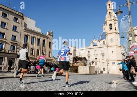 Die Teilnehmer des Halbmarathons Alcoy 2024 werden von Batucada auf der Plaza de España ermutigt Stockfoto