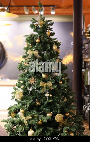 Dies ist ein eleganter und festlich dekorierter Weihnachtsbaum mit wunderschönen Goldakzenten Stockfoto