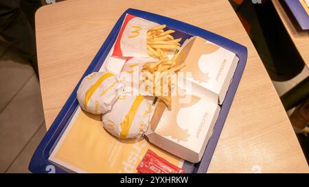 Blick von oben auf McDonald's Essenstablett mit Burgern, McChicken Sandwiches, Pommes Frites und Ketchup-Paketen in einem Fast-Food-Restaurant, keine Leute, t Stockfoto