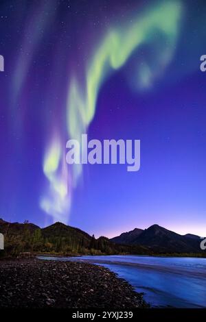 Die Aurora Borealis wirkt wie eine Rauchsäule, während sie über dem Koyukuk River über dem Polarkreis in Wiseman, Alaska, tanzt Stockfoto