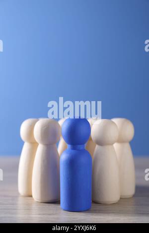 Personalkonzept. Blaue Figur unter hölzernen auf dem Tisch, Nahaufnahme. Leerzeichen für Text Stockfoto