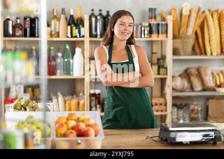 Porträt einer lächelnden Verkäuferin auf der Schürze hinter dem Supermarkt Stockfoto