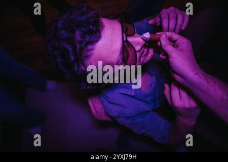 Eine Gruppe von Freunden, die sich während einer Geburtstagsparty zu Hause amüsieren, Lachen und verspielte Momente festhalten. Stockfoto