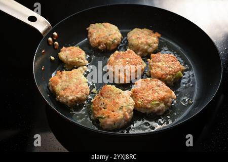 Fischkuchen oder Frikadellen vom Lachs werden in einer schwarzen Pfanne geröstet, zum Abendessen gekocht oder Fingerfood für ein Partybuffet, Kopierraum, ausgewählt für Fo Stockfoto