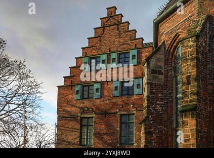 Historisches Gebäude an der Martini-Kirche in Bremen in roter Backsteinarchitektur mit Stufengiebel und Holzläden, bewölkter Himmel, ausgewählter Fokus Stockfoto