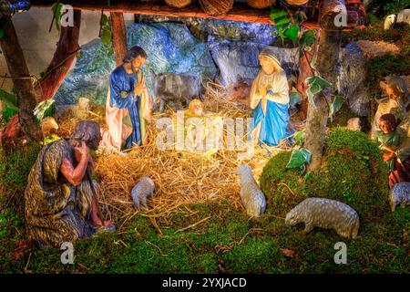 Weihnachtskrippe mit dem Baby Jesus, Maria und Joseph in der Scheune mit Schafen und Hirten Stockfoto