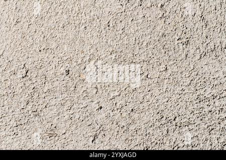 Abstrakte Textur einer verwitterten Pflasterwand mit detaillierten Mustern und dezenten Farbvariationen Stockfoto