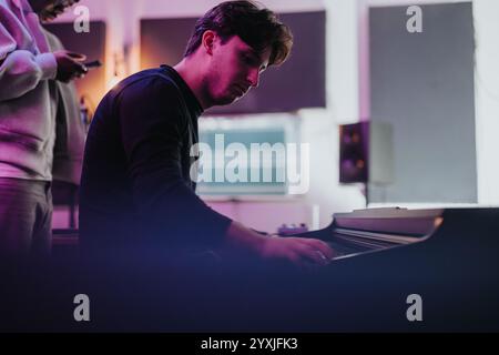 Multirassische Musiker arbeiten in einem modernen Studio-Setting zusammen Stockfoto