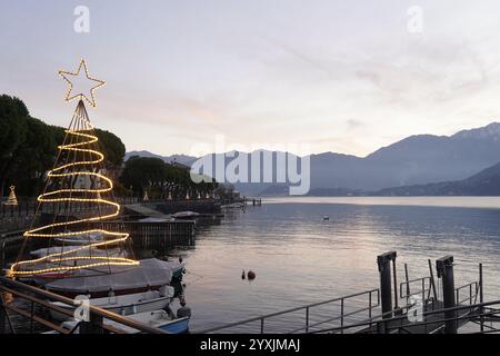 Am See von Lenno mit Weihnachtsdekorationen bei Sonnenaufgang, im Hintergrund Bellagio und seine Landzunge. Comer See, Italien Stockfoto