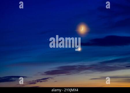 Verbindung des wachsenden Halbmondes mit Venus und Mars in einem bunten Dämmerhimmel. Stockfoto