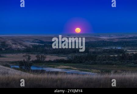 Supermoon, der über den Bow River und das Tal im Süden von Alberta, Kanada, aufsteigt. Stockfoto