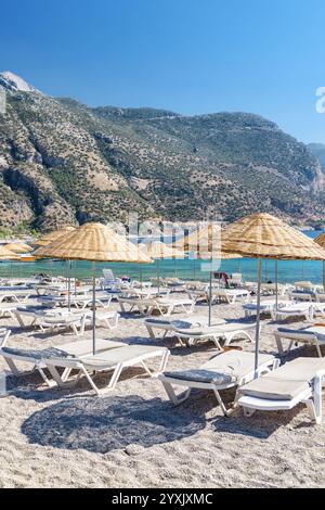Sonnenschirme und Liegestühle am Oludeniz Beach in der Türkei Stockfoto