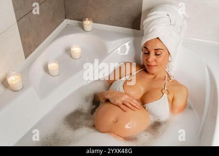 Schwangere Frau genießt ein Blasenbad Stockfoto