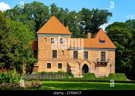 Oporow, Polen - 17. August 2024: Mittelalterliche Ritterburg Oporowskich mit nassem Graben und Zugbrücke im historischen Park im Dorf Oporow Stockfoto