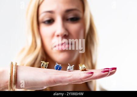 Vier kleine Geschenke liegen auf der Hand einer jungen Frau. Dahinter, verschwommen, ihr unzufriedenes Gesicht. Vielleicht ist es der Gedanke, der zählt, aber was man gesehen hat, ist der Stockfoto