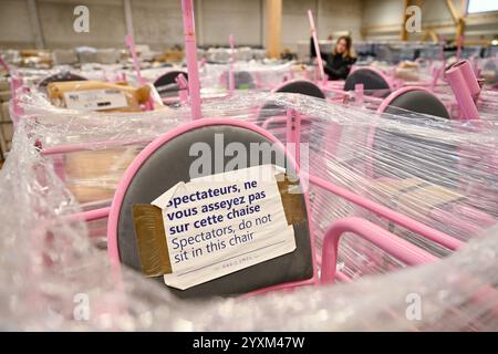 Kaiserslautern, Deutschland. Dezember 2024. Ein Mitarbeiter steht hinter Schiedsrichterstühlen in einem Lagerhaus. Tausende von Objekten der Olympischen Sommerspiele in Paris werden nach einer Internetauktion aus einem Lager an erfolgreiche Bieter übergeben. Eine Firma hatte 50.000 Artikel gekauft – von Sofas über Sonnenschirme und Schiedsrichterstühle bis hin zu Tischfußball – um dem Material ein zweites Leben zu geben. Quelle: Uwe Anspach/dpa/Alamy Live News Stockfoto