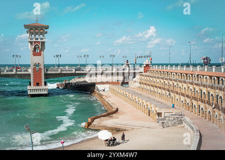 Die Stanley Bridge in Alexandria, Ägypten, besticht durch ihren berühmten Turm und das türkisfarbene Wasser des Mittelmeers, neben der historischen Strandpromenade unter hellem Himmel. Stockfoto