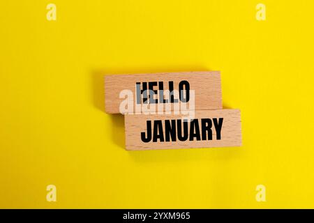 Hallo januar Nachricht geschrieben auf Holzblöcken mit gelbem Hintergrund. Konzeptionelles Hallo januar-Symbol. Kopierbereich. Stockfoto