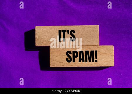 Es ist eine Spam-Nachricht auf Holzblöcken mit violettem Hintergrund. Konzeptionell ist das Spam-Symbol. Kopierbereich. Stockfoto