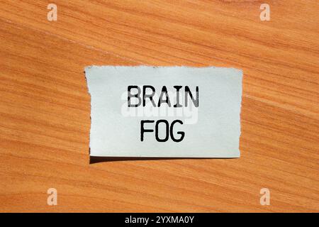 Hirnnebelbotschaft geschrieben auf zerrissenem Papierstück mit hölzernem Hintergrund. Konzeptionelles Hirnnebelsymbol. Kopierbereich. Stockfoto
