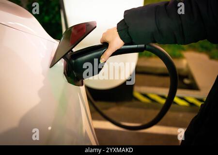 Elektrofahrzeug mit der Hand an die Kompressorstation anschließen Stockfoto