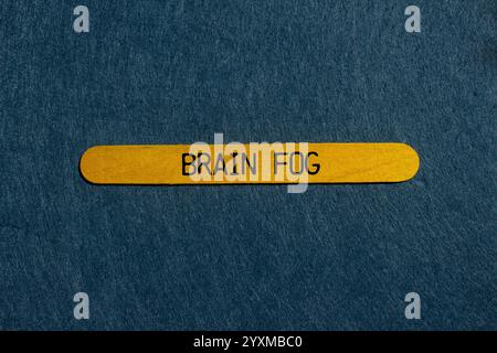 Hirnnebel-Nachricht auf gelbem Holzstab mit grauem Hintergrund. Konzeptionelles Hirnnebelsymbol. Kopierbereich. Stockfoto