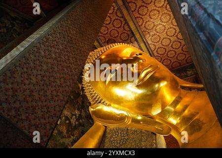 Bangkok, Thailand - 29. November 2024: Nahaufnahme des Gesichts der Statue des liegenden Buddha am berühmten Wat Pho Tempel Stockfoto