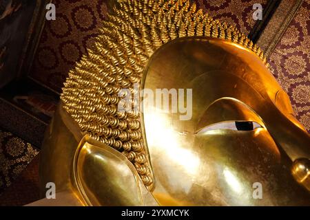 Bangkok, Thailand - 29. November 2024: Gesichtsbereich der liegenden Buddha-Goldstatue. Wat Pho Tempel Stockfoto