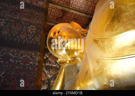 Bangkok, Thailand - 29. November 2024: Der liegende Buddha im Wat Pho Tempel, majestätische und große goldene Statue in asien Stockfoto