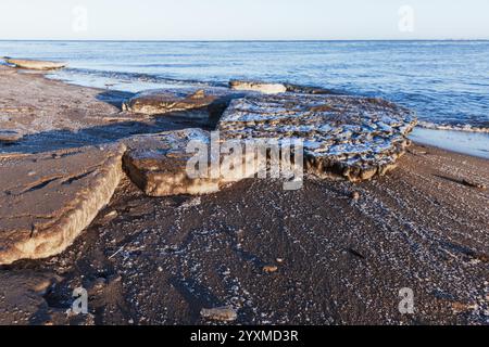 Schmutzige Eisschollen lagen an der Ostseeküste auf einem natürlichen Wintergrund Stockfoto