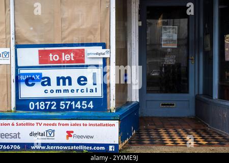 Ein geschlossener und verschlossener heruntergekommener Laden kann im Stadtzentrum von Newquay in Cornwall in Großbritannien vermietet werden. Stockfoto