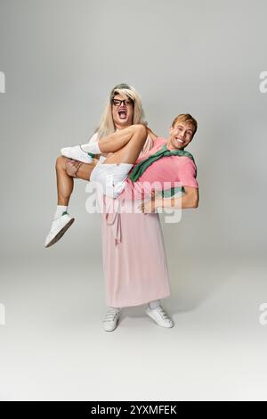 Zwei Personen zeigen Freude und Kreativität mit verspielten Posen, die queeren Stolz zeigen. Stockfoto