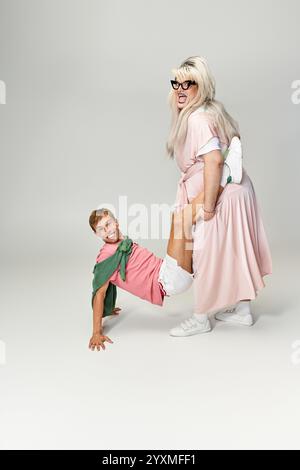 Zwei Individuen zeigen auffällige Styles und verspielte Energie in einem farbenfrohen Studiohintergrund. Stockfoto