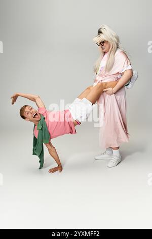 Zwei dynamische Individuen spielen einen unterhaltsamen und energiegeladenen Tanz, der queere Freude und Kreativität zum Ausdruck bringt. Stockfoto