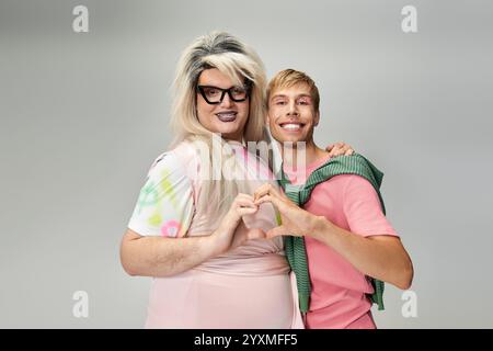 Zwei Individuen drücken ihre Liebe aus und zeigen Stolz und lebendige Styles in einem Studio-Setting. Stockfoto