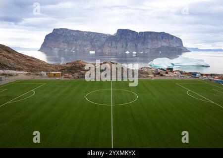 Uummannaq Football Field, nordwestlich von Grönland, auf einer Insel. Eisberge im Uummannaq-Fjord. Große Berge und Gletscher im Hintergrund. Stockfoto