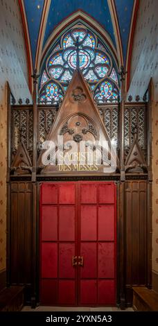 Paris, Frankreich - 12 16 2024: Notre Dame de Paris. Sehen Sie die Sakristei mit Massen Holztor und ein rosafarbenes Buntglasfenster in der Kathedrale Stockfoto