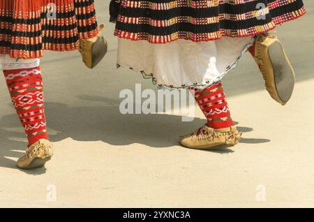 Bulgarische Folklore. Mädchen tanzen Volkstanz. Menschen in traditionellen Kostümen tanzen bulgarische Volkstänze. Nahaufnahme der weiblichen Beine mit traditionellem Sho Stockfoto