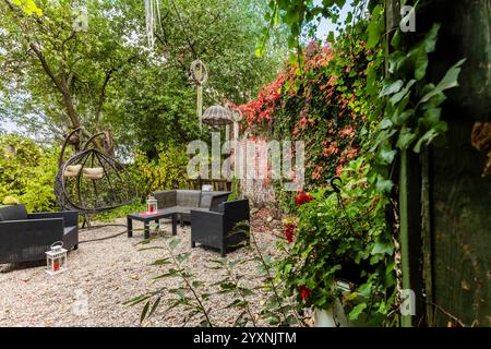 Charmanter Garten mit Möbeln, umgeben von Blumen und Vegetation in Ciechocinek, Polen Stockfoto