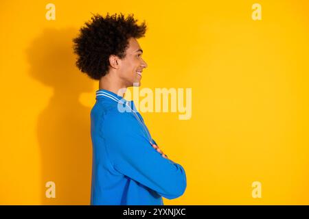 Foto-Porträt des gutaussehenden jungen Mannes überkreuzte Hände Profil gekleidetes stilvolles blaues Kleid isoliert auf gelbem Hintergrund Stockfoto