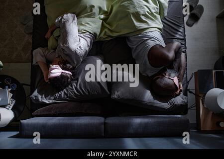 Top-Down-Schuss eines zweirassigen Paares, das zusammen im Bett schläft Stockfoto