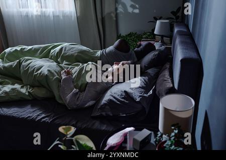 Hochwinkelaufnahme von unerkennbarer Frau und Ehemann, die in einem bequemen Bett schlafen Stockfoto