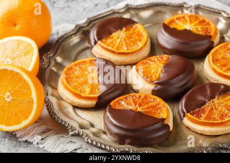 Hausgemachte Shortbread-Kekse mit kandierter Orange und Schokoladenglasur in Nahaufnahme auf einem Teller auf dem Tisch. Horizontal Stockfoto