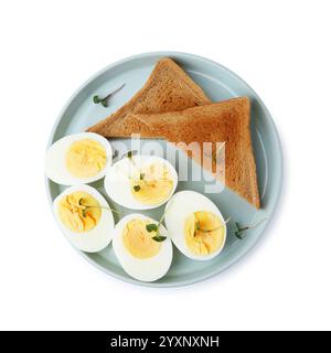 Hälften hart gekochter Eier und Brot isoliert auf weiß, Blick von oben Stockfoto