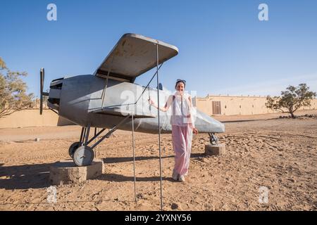 Eine schöne Frau mittleren Alters posiert am Eingang eines Hotels in der Sahara in der Region Merzouga, Marokko. Es handelt sich um die kleine Ebene, die in der verwendet wird Stockfoto