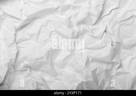 Zerknittertes weißes Papier bildet einen abstrakten, strukturierten Hintergrund, der mit seinen komplizierten Falten und Falten ein fesselndes Bild zeigt und ein einzigartiges s schafft Stockfoto